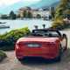 Maserati GranCabrio Folgore review: rear three quarter static, lake in background, orange paint