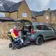 Image of a wheelchair accessible Dacia Jogger, with a wheelchair user about to go up the ramp