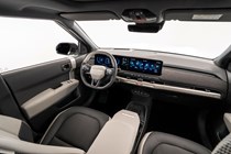 Kia EV3 (2024) reveal: dashboard and infotainment system over driver's shoulder, black and cream upholstery