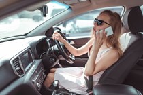The cost of using your phone at the wheel, woman calling someone while driving