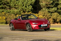 Mazda MX-5 review - front view, red, roof down, driving round corner