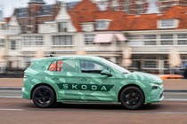 Skoda Elroq prototype: side view driving, in a city, green camo wrap