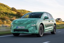 Skoda Elroq prototype: front three quarter driving, on a country road, green camo wrap