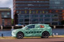 Skoda Elroq prototype: side view driving, in a city, sunshine, green camo wrap