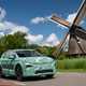 Skoda Elroq prototype: front three quarter driving, windmill in background, green camo wrap