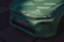 Skoda Elroq prototype: detail shot of bonnet and headlights, green camo wrap