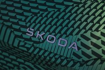 Skoda Elroq prototype: detail shot of bonnet badge, green camo wrap