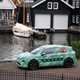 Skoda Elroq prototype: front three quarter static, green camo wrap, river and boat in background