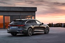 Audi S5 Avant (2024): rear three quarter static, modern house in background, grey paint