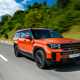 Hyundai Santa Fe (2024) review: front three quarter driving, wide angle, orange paint