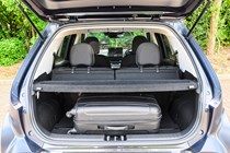 Hyundai Inster review, black, boot capacity, seats up, parcel shelf in place, suitcase | Parkers