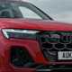 Audi Q7 (2025) review: LED headlight and radiator grille detail, red paint