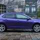 Volkswagen Polo (2024) review: side view static, old building in background, purple paint