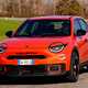 Abarth 600e (2024) review: front three quarter driving, orange paint