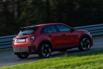 Abarth 600e (2024) review: rear three quarter cornering, orange paint