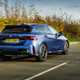 BMW M135 (2024) review: rear three quarter driving, matte blue paint