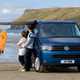 Image of the Volkswagen T5.1 California, in blue, with awning set-up, viewed from the front