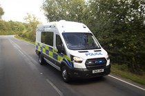 Image of Ford Transit police van driving with lights flashing