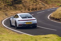 Image of a Porsche 911 GTS driving round a corner, viewed from the rear