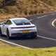 Image of a Porsche 911 GTS driving round a corner, viewed from the rear