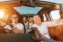 Image of a family having fun while out for a drive, shot from the car's dashboard