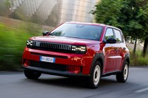 Fiat Panda (2025) review: front three quarter driving, red paint, offset angle, city background