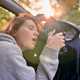 Image of a woman sleeping at the wheel of a car