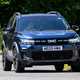 Dacia Bigster (2025) review: front three quarter driving, blue paint, low angle