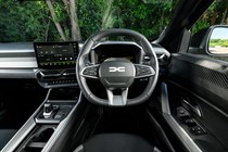 Dacia Bigster (2025) review: steering wheel and driver's seat, black and grey upholstery