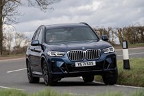 BMW X3 review (2023): front three quarter cornering shot, showing body roll, blue car, rural background
