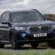 BMW X3 review (2023): front cornering shot, blue car, rural background