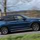 BMW X3 review (2023): driver's side pan shot, blue car, rural background