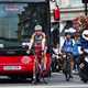 Image of cyclists waiting at traffic lights near a bus