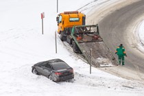 Image of a recovery truck rescuing a Lexus IS that's gone off a snowy road