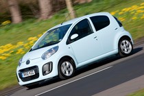 Image of a light blue 2012 Citroen C1 driving, front the front left corner