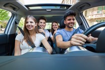 Image of four young people riding in a car