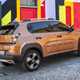 Fiat Grande Panda Hybrid (2025) review: rear three quarter cornering, bronze paint, colourful house in background