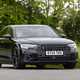 Image of a black Audi S8 driving around a corner, looking at its front right corner