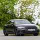 Image of a black Audi S8 driving around a corner, looking at its front right corner