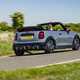 Image of a grey MINI JCW convertible driving round a corner, viewed from the rear
