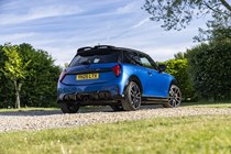 Image of a static blue MINI JCW, viewed from the rear right corner at a low angle