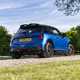 Image of a static blue MINI JCW, viewed from the rear right corner at a low angle