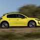 Peugeot E-208 review - facelift, side view, driving, yellow