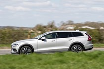 Volvo V60 Cross Country (2023) review: side view driving, taken from passenger-side of car, silver paint, rural background