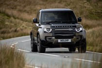 Gold 2021 Land Rover Defender 90 driving front three-quarter