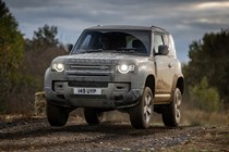 Gold 2021 Land Rover Defender 90 driving off-road front three-quarter