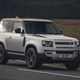 Silver 2021 Land Rover Defender 90 driving front three-quarter