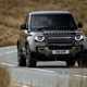 Gold 2021 Land Rover Defender 90 driving front three-quarter