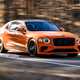 Bentley Flying Spur review - V8 plug-in hybrid, Mandarin orange, front, driving round corner