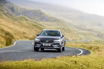 Volvo XC60 T6 Recharge, front view, driving round corner, grey